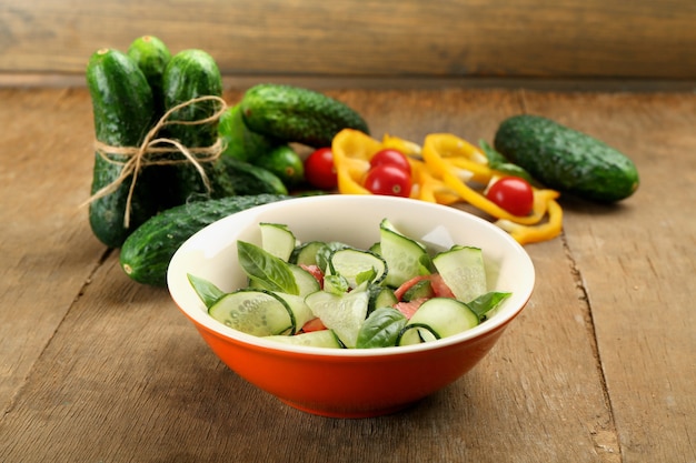 Groentesalade met komkommers op houten tafel