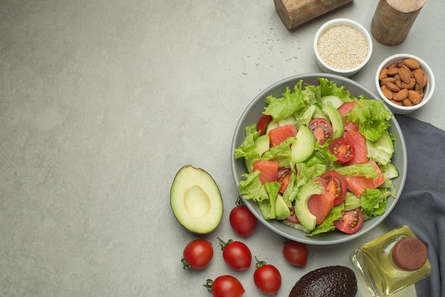 Groentesalade met tomaten, avocado en komkommer op een grijze achtergrond