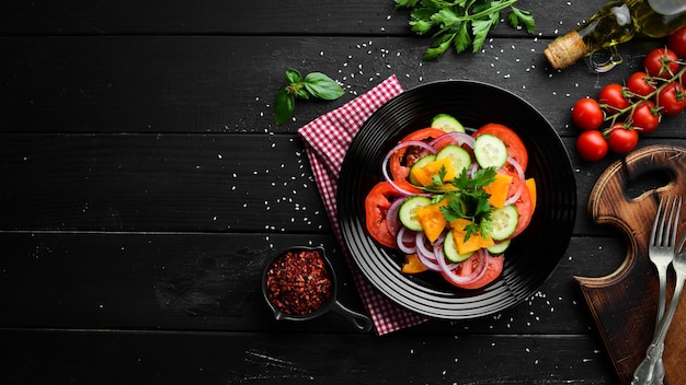 Groentesalade. Tomaten, komkommer, uien, peterselie. Bovenaanzicht. Vrije ruimte voor uw tekst.