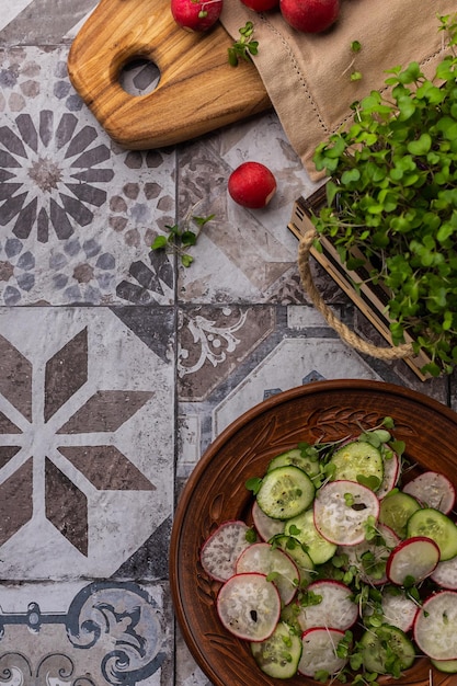 Groentesalade van verse radijs en komkommer met microgreens op een keukenbord