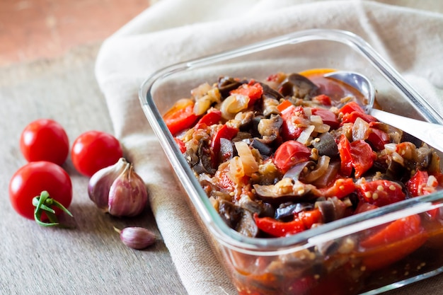 Groentesaus met aubergine rode paprika en tomaten in glazen kom