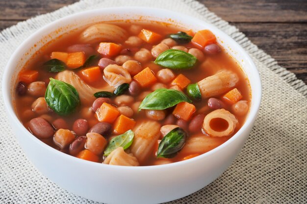 Groentesoep met bonen en pasta gegarneerd met groene basilicum bladeren