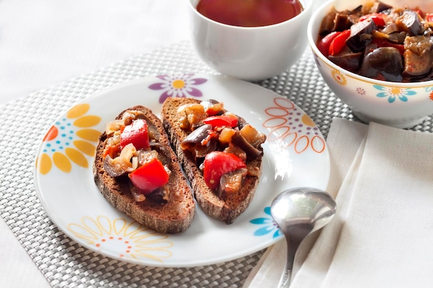 Groentestoofpot met aubergine rode paprika en tomaten op geroosterd roggebrood