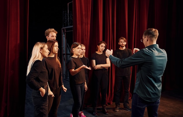 Foto groep acteurs in donkere kleding op repetitie in het theater