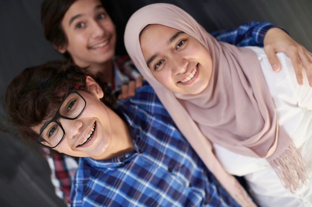 groep Arabische tieners die selfie-foto maken op smartphone met zwart bord op de achtergrond