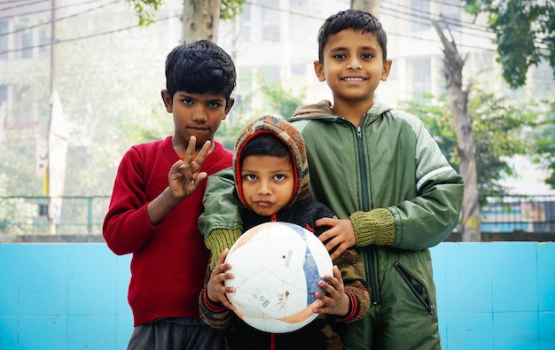 Groep arme Indiase kinderen met voetbal glimlachen