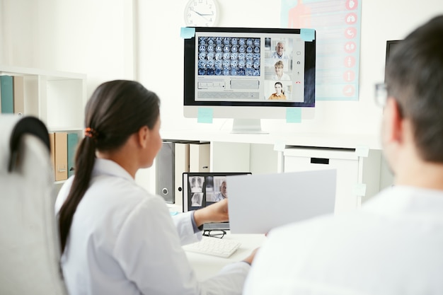 Groep artsen op computermonitor x-ray beelden bespreken met collega's tijdens online conferentie