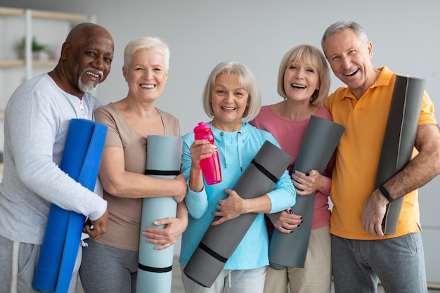 Groep atletische gepensioneerden die yogales bijwonen in retraitecentrum