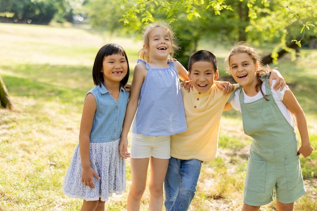 Groep aziatische en blanke kinderen die plezier hebben in het park