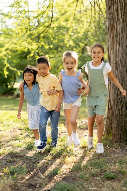 Groep aziatische en blanke kinderen die plezier hebben in het park