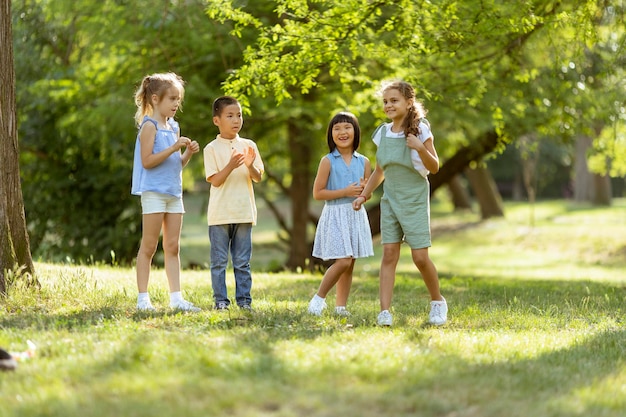 Groep aziatische en blanke kinderen die plezier hebben in het park