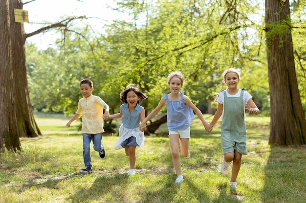 Groep aziatische en blanke kinderen die plezier hebben in het park