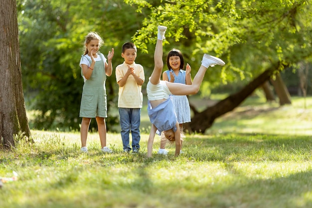 Groep aziatische en blanke kinderen die plezier hebben in het park