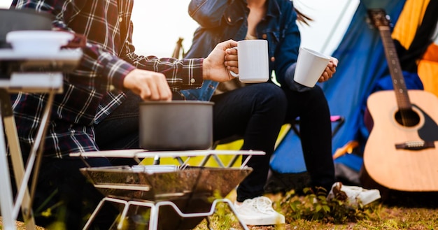 Groep Aziatische jongeren zitten koffie te drinken en gitaar te spelen om gelukkig te zijn