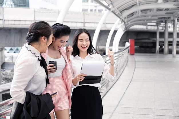 Groep aziatische zakenvrouwen blij in succesvol werken met een glimlach op buiten in de stad. Concept groepswerk Aziatische vrouw. Thaise vrouwenbeambtegroep.