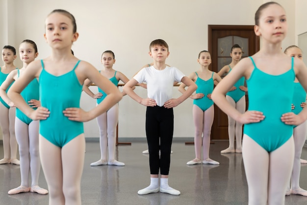 Groep ballerina's die bij balletstaaf trainen