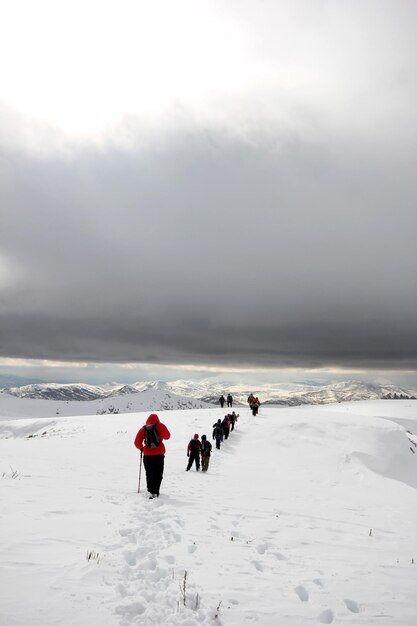 Groep bergbeklimmers wandelen door de bergen bedekt met snowxAxA