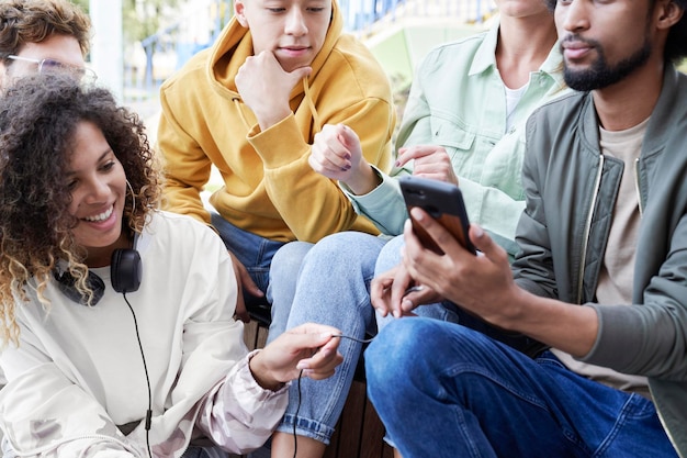 Groep beste vrienden die samen zitten met mobiele telefoon