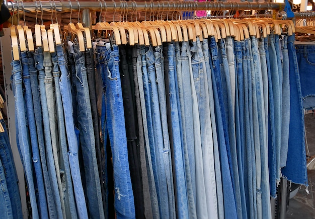 Groep blauwe denimjeans die op een rek hangen