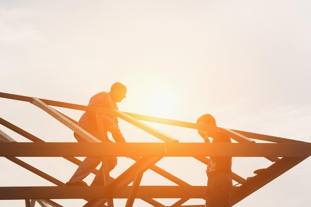 Groep bouwers bovenaan de metalen structuur in het zonlicht