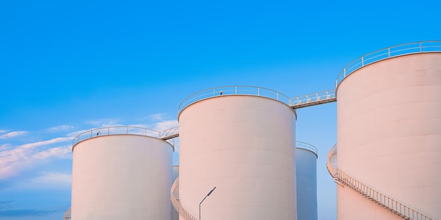 Foto groep brandstoftanks in een olie-industrie-productiegebied tegen een blauwe achtergrond