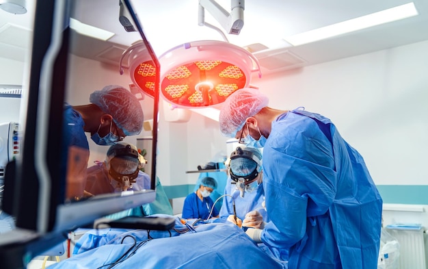 Groep chirurgen in operatiekamer met chirurgische apparatuur Werken met chirurgische instrumenten