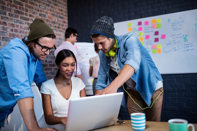 Groep collega's die een computer met behulp van