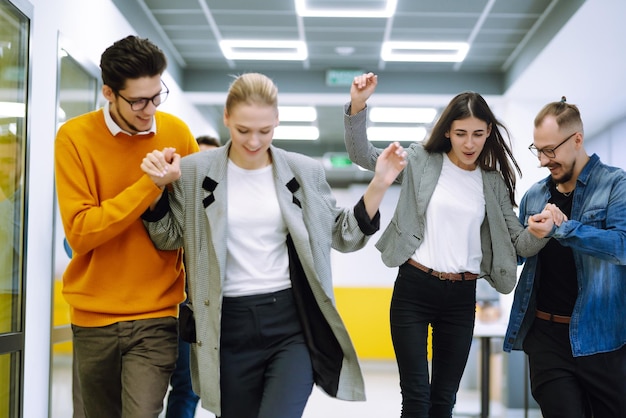 Groep collega's die plezier hebben met skateboard op kantoor