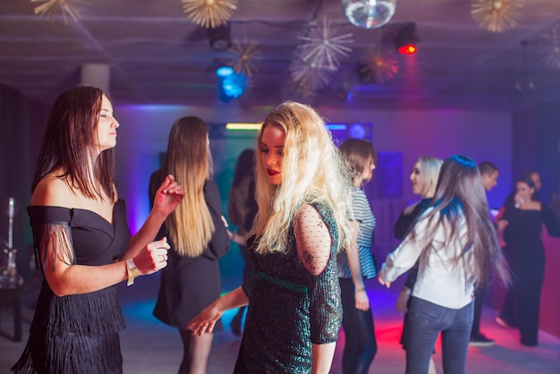 Groep dansende jongeren die van de nacht in de club genieten