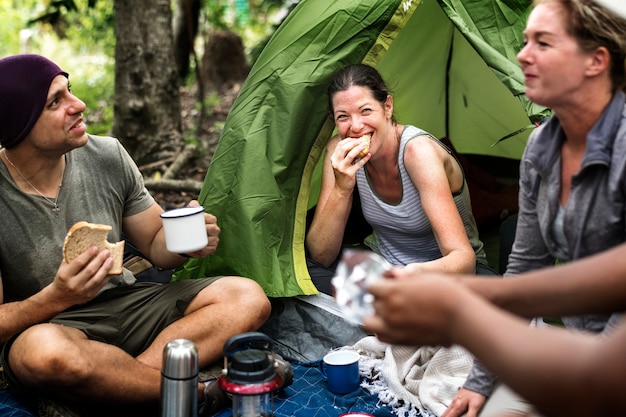 Groep diverse vrienden die in het bos kamperen