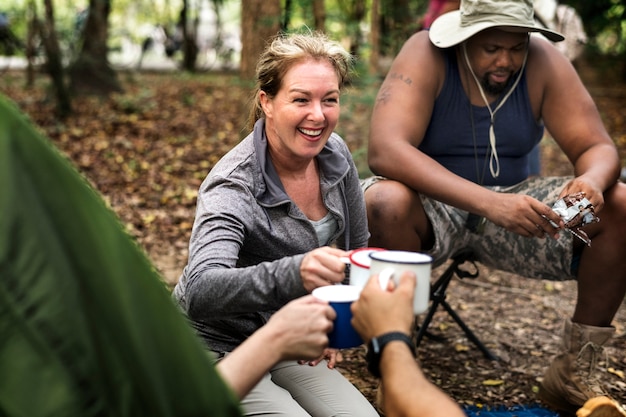 Groep diverse vrienden die in het bos kamperen