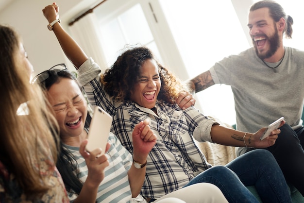 Groep diverse vrienden die spel op mobiele telefoon spelen