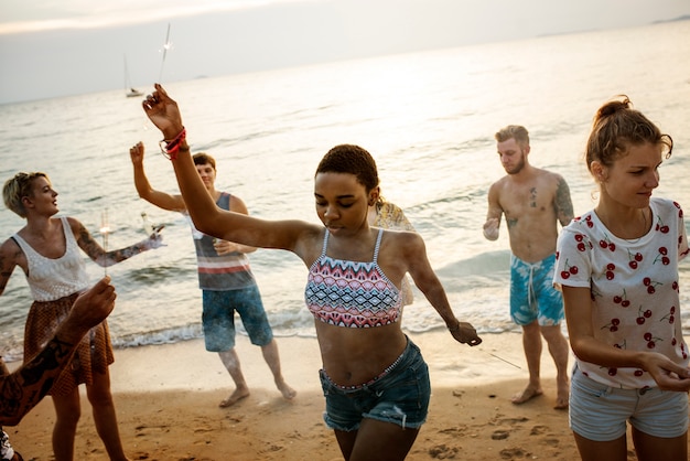 Groep diverse vrienden die van sterretjes bij het strand samen genieten