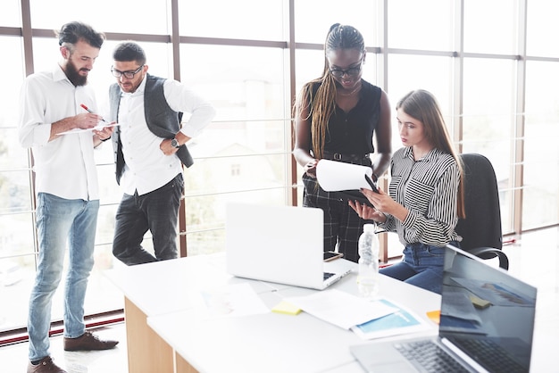 Groep freelancers die in het ruime kantoor met grote ramen werken