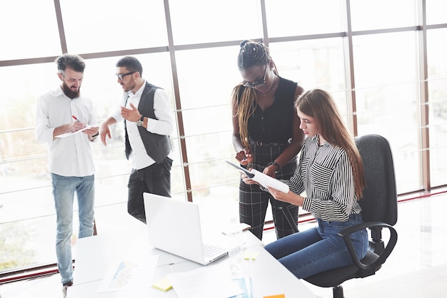 Groep freelancers die in het ruime kantoor met grote ramen werken