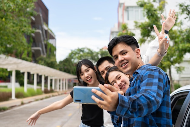 Groep gelukkige jonge Aziatische studenten selfies en video's met smartphones samen voor vlog