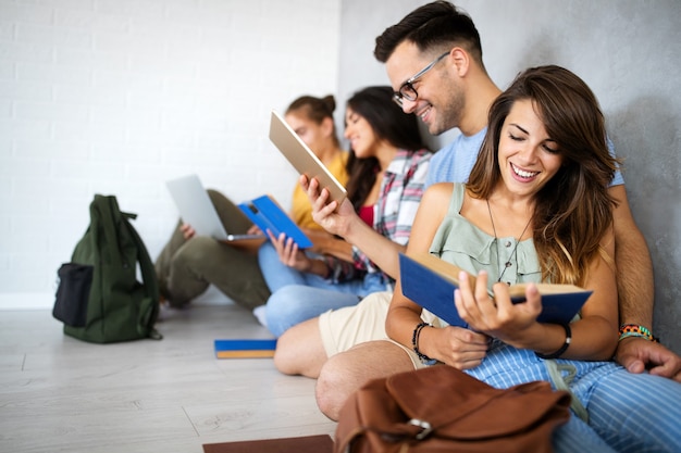 Groep gelukkige jonge studenten die plezier hebben terwijl ze samen studeren voor examens