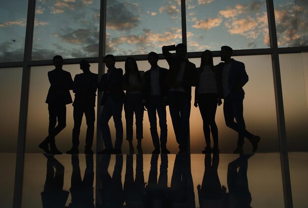 Groep gelukkige jonge zakenmensen die in de buurt van een groot loket staan, het concept van teamwork