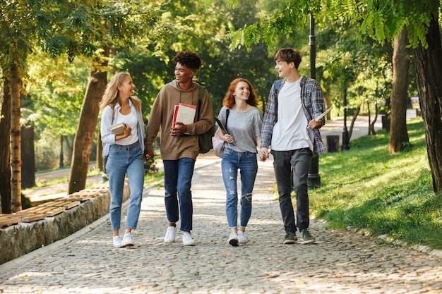 Groep gelukkige studenten die buiten op de campus lopen