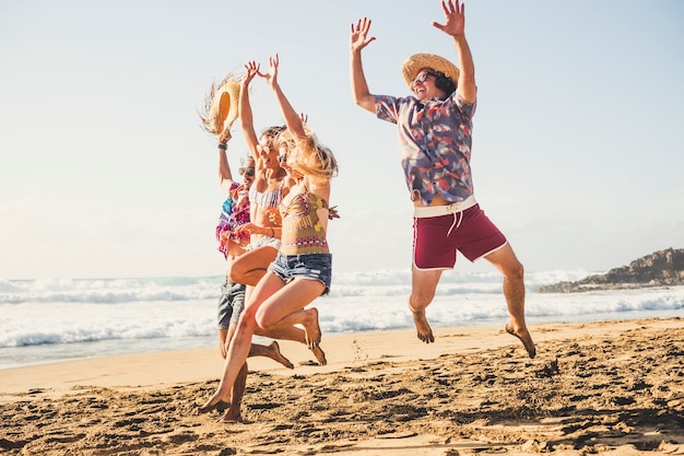 Foto groep gelukkige toeristensprong op het strand