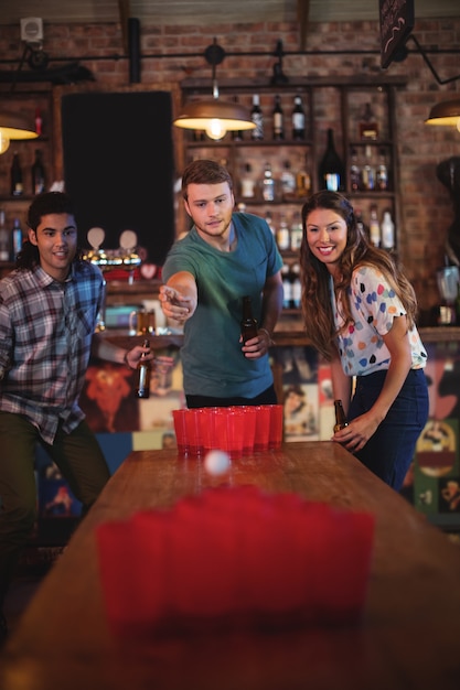 Groep gelukkige vrienden die bierpongspel spelen