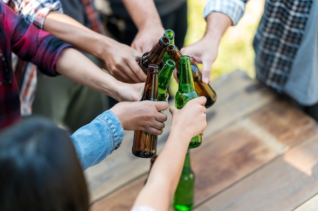 Foto groep gelukkige vrienden die een gezonde levensstijl leven en ontspannen juichen met bier en bier drinken