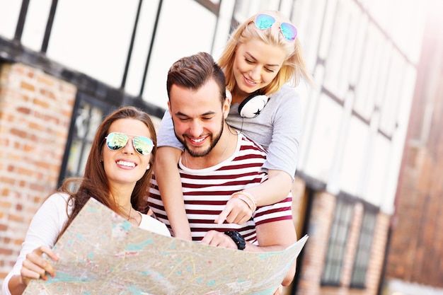 groep gelukkige vrienden die Gdansk bezoeken met kaart