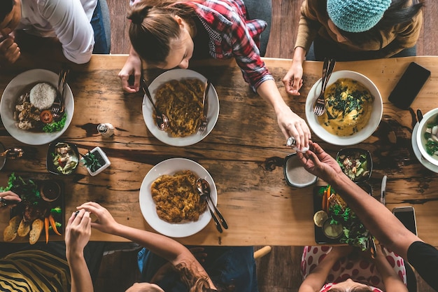 Foto groep gelukkige vrienden die lekker eten en drinken genieten van het feest en de communicatie bovenaanzicht van familie die thuis samenkomt om te eten