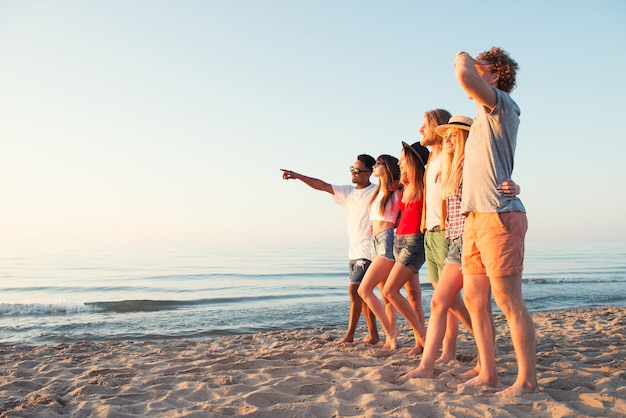 Groep gelukkige vrienden die pret hebben bij oceaanstrand