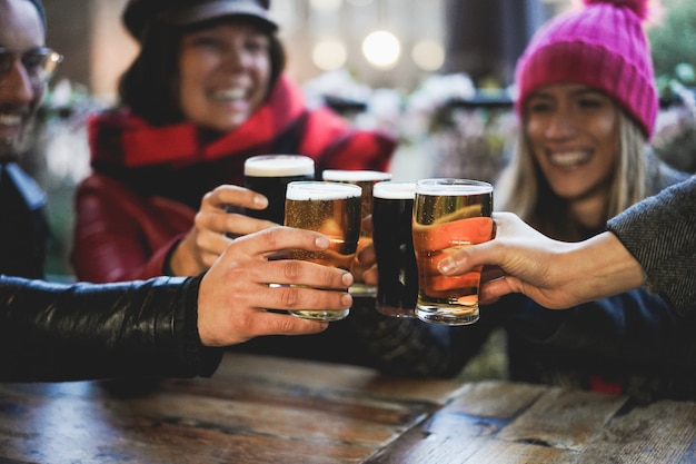Groep gelukkige vrienden drinken en roosteren bier bij brouwerij bar restaurant