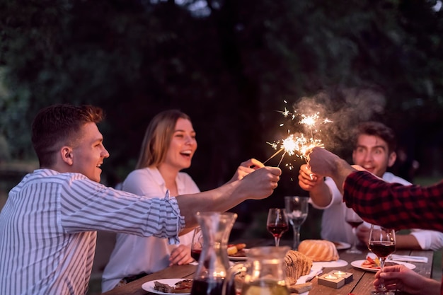 groep gelukkige vrienden hebben een picknick Frans etentje buiten tijdens de zomervakantie vakantie in de buurt van de rivier in de prachtige natuur