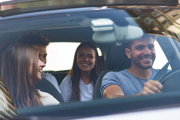 Groep gelukkige vrienden op een auto