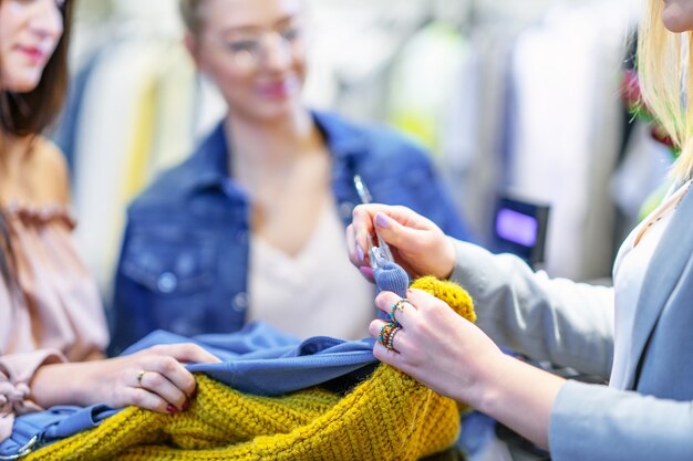 Groep gelukkige vrienden winkelen voor kleding in winkelcentrum