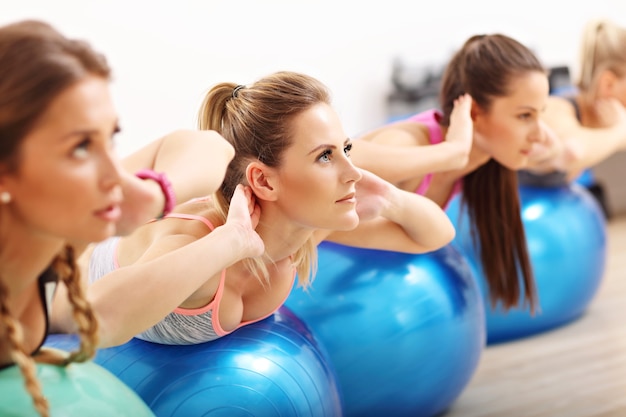 Groep gelukkige vrouwen die aerobics doen met fitballen